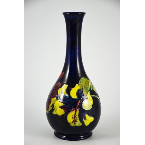 1087 - Walter Moorcroft, a Hibiscus vase, circa 1960s, elongated neck baluster form, on blue, impressed mar... 