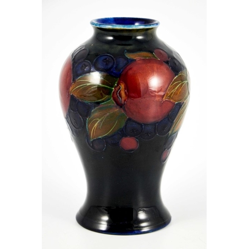 1125 - William Moorcroft, a Pomegranate on blue vase, circa 1928, inverse baluster form, impressed marks an... 