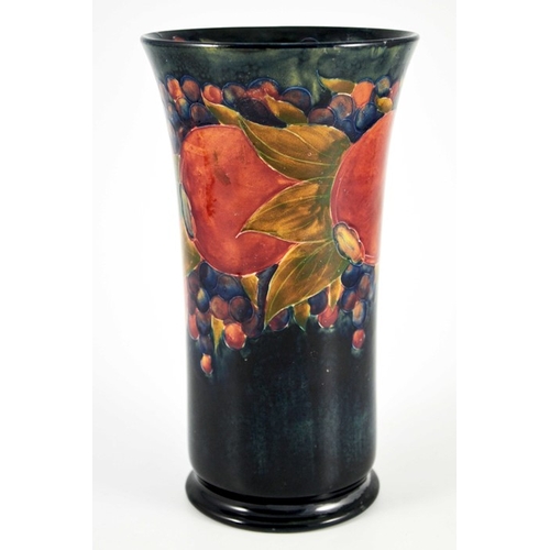 1134 - William Moorcroft, a Pomegranate on ochre and blue vase, circa 1915, cylindrical trumpet form, on fo... 