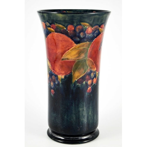 1134 - William Moorcroft, a Pomegranate on ochre and blue vase, circa 1915, cylindrical trumpet form, on fo... 