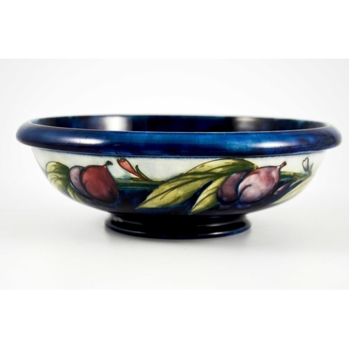 1137 - William Moorcroft, a Wisteria on blue bowl, circa 1923, shallow footed form, the exterior with white... 