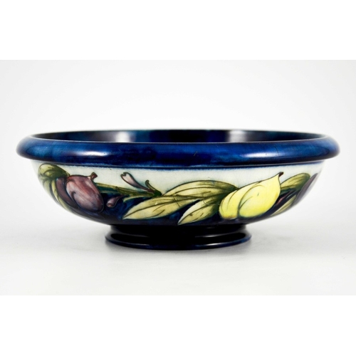 1137 - William Moorcroft, a Wisteria on blue bowl, circa 1923, shallow footed form, the exterior with white... 