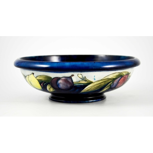 1137 - William Moorcroft, a Wisteria on blue bowl, circa 1923, shallow footed form, the exterior with white... 