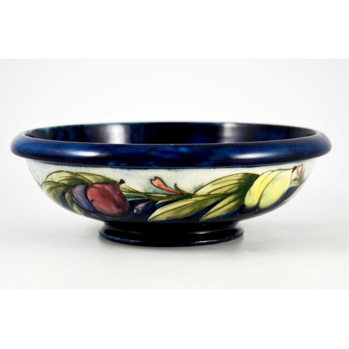 1137 - William Moorcroft, a Wisteria on blue bowl, circa 1923, shallow footed form, the exterior with white... 