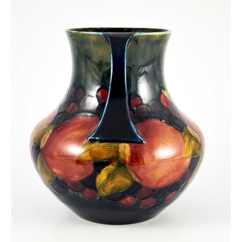 1145 - William Moorcroft, a Pomegranate on ochre and blue vase, circa 1920, twin handled amphora form, impr... 