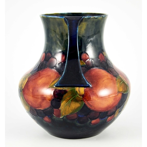 1145 - William Moorcroft, a Pomegranate on ochre and blue vase, circa 1920, twin handled amphora form, impr... 