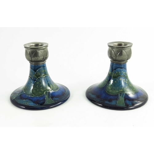 1146 - William Moorcroft, a pair of Moonlit Blue candlesticks, circa 1925, of squat form with Libertys Tudr... 