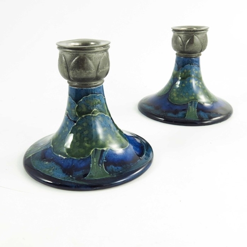 1146 - William Moorcroft, a pair of Moonlit Blue candlesticks, circa 1925, of squat form with Libertys Tudr... 