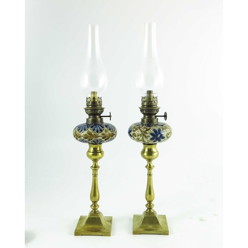 1231 - A pair of Doulton Lambeth stoneware table oil lamps, 1884, squat ovoid reservoirs decorated with fol... 