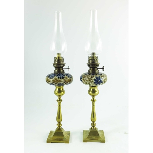 1231 - A pair of Doulton Lambeth stoneware table oil lamps, 1884, squat ovoid reservoirs decorated with fol... 