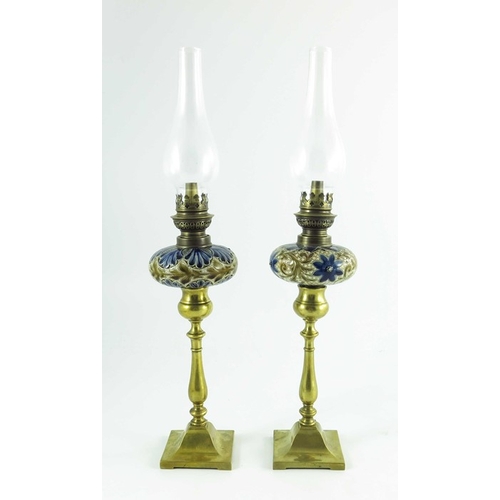 1231 - A pair of Doulton Lambeth stoneware table oil lamps, 1884, squat ovoid reservoirs decorated with fol... 