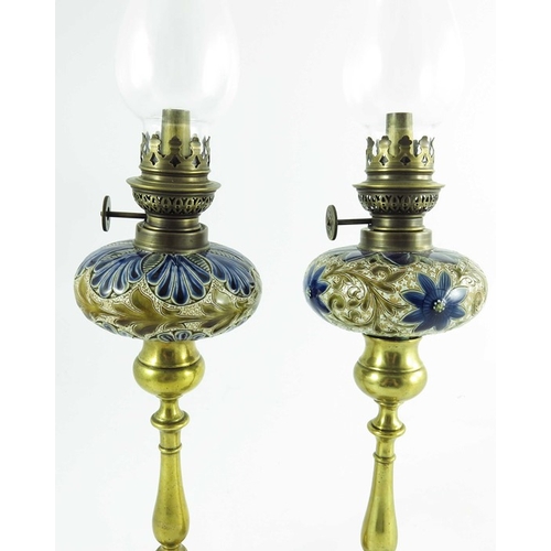 1231 - A pair of Doulton Lambeth stoneware table oil lamps, 1884, squat ovoid reservoirs decorated with fol... 