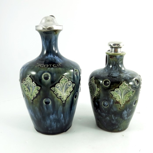 1233 - Two Doulton Lambeth stoneware whisky flagons, circa 1903, each of shouldered form, with dimpled and ... 