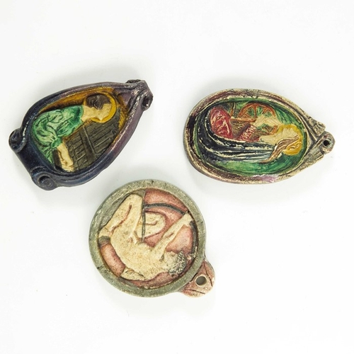 1260 - Mary Watts for Compton Pottery, three ceramic pendants, relief moulded, including St Catherine, St C... 