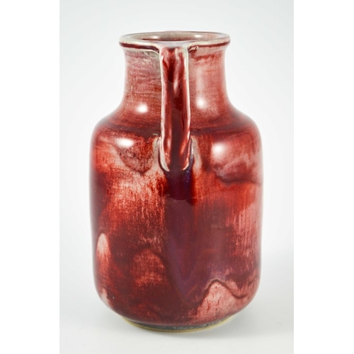 1343 - A Ruskin high fired twin handled vase, circa 1925, cylindrical shouldered form with angled handles, ... 