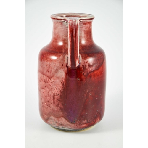 1343 - A Ruskin high fired twin handled vase, circa 1925, cylindrical shouldered form with angled handles, ... 