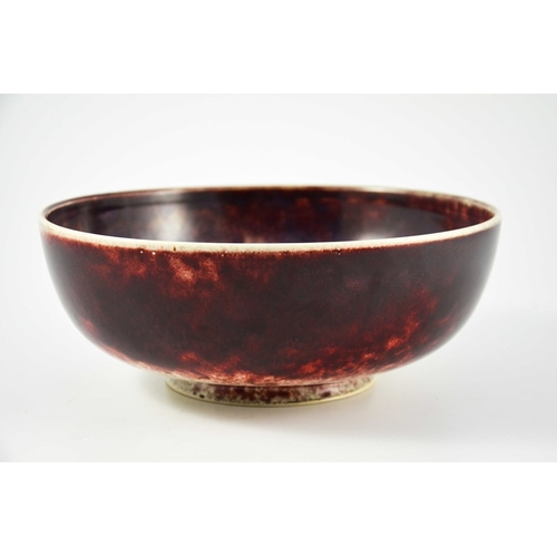 1345 - A large Ruskin high fired bowl, 1926, squat rounded form, the exterior in red draining to white, the... 