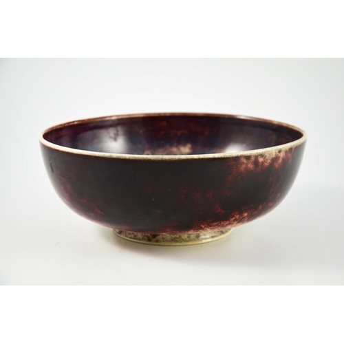 1345 - A large Ruskin high fired bowl, 1926, squat rounded form, the exterior in red draining to white, the... 