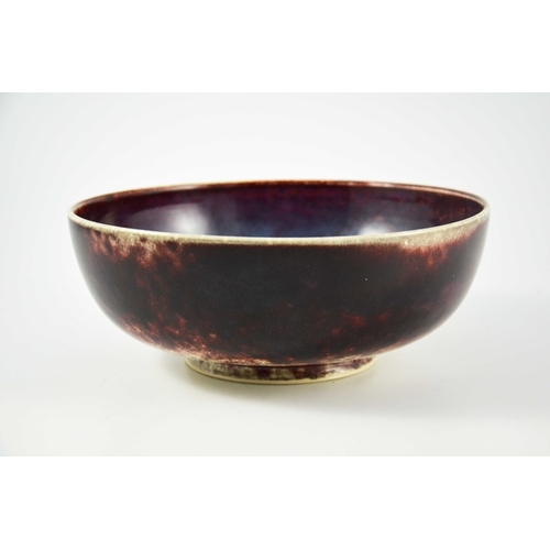 1345 - A large Ruskin high fired bowl, 1926, squat rounded form, the exterior in red draining to white, the... 