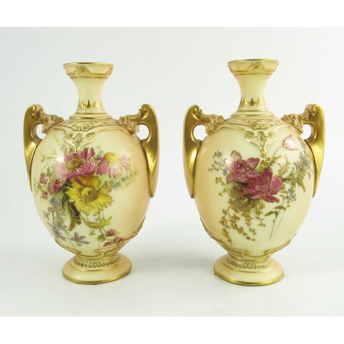 1450 - A pair of Royal Worcester blush ivory ground two handle vases, florally decorated to two sides in co... 