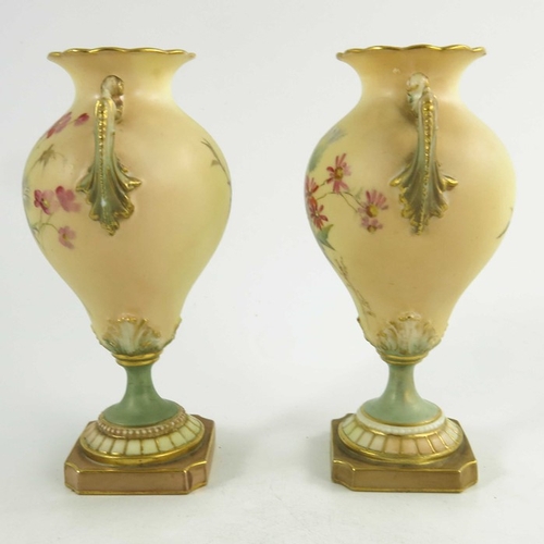 1460 - A pair of Royal Worcester miniature blush ivory ground two handled vases, florally decorated with th... 