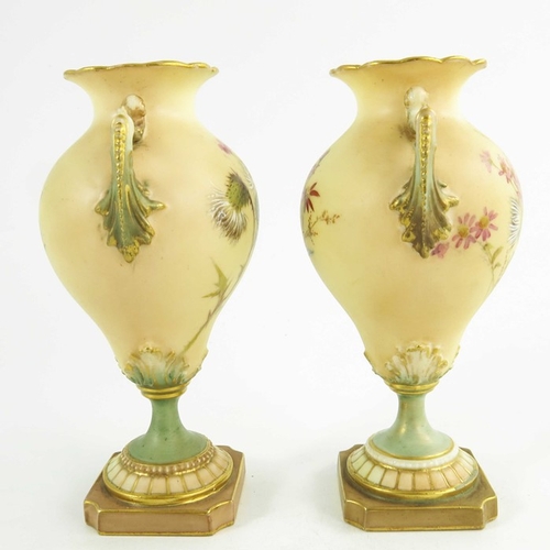 1460 - A pair of Royal Worcester miniature blush ivory ground two handled vases, florally decorated with th... 