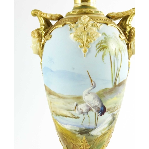 1472 - Walter Powell for Royal Worcester, a mask handle vase of slender ovoid form, painted with storks in ... 