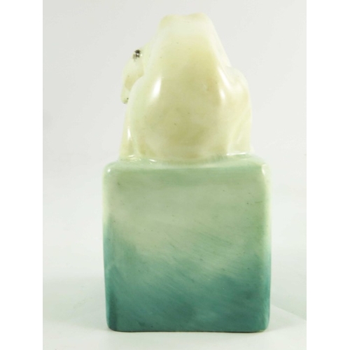 1509 - A Royal Doulton figure, circa 1920, a polar bear on a cube, 10cm high