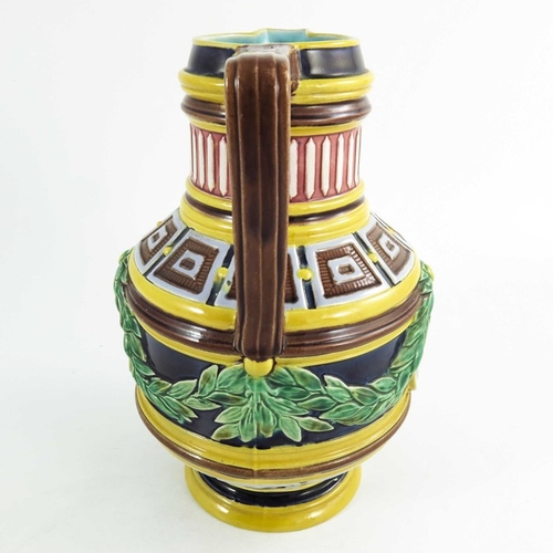 1513 - A Wedgwood majolica jug, circa 1870, cylindrical baluster form, relief moulded with classical portra... 