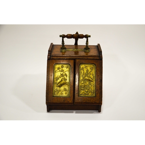 555 - An Aesthetic Movement walnut and brass panelled mechanical coal scuttle, the twin doors opening with... 