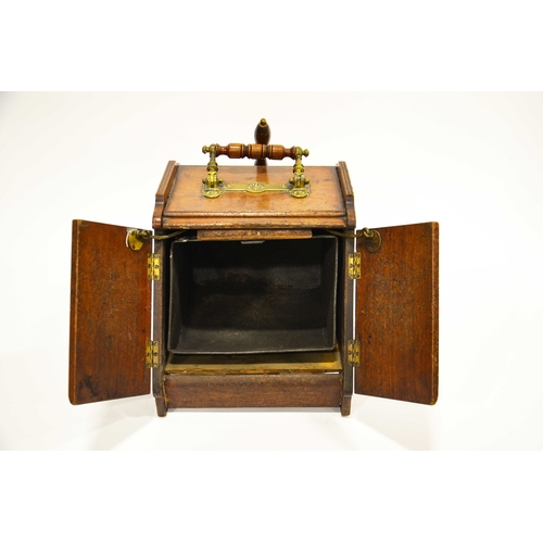 555 - An Aesthetic Movement walnut and brass panelled mechanical coal scuttle, the twin doors opening with... 