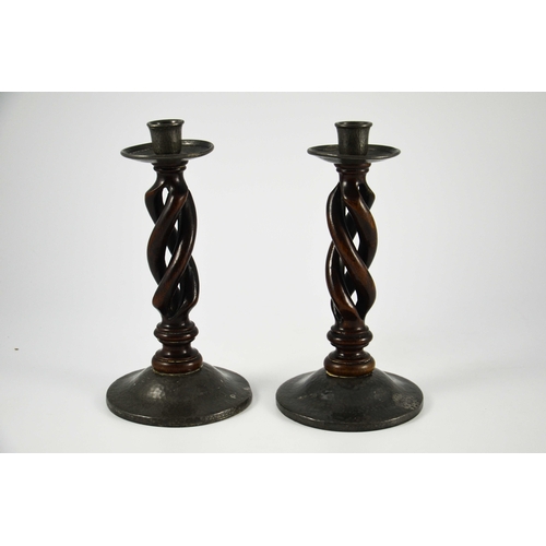 617 - Liberty and Co., pair of Tudric pewter and oak candlesticks, model 01298, open barley twist with pla... 