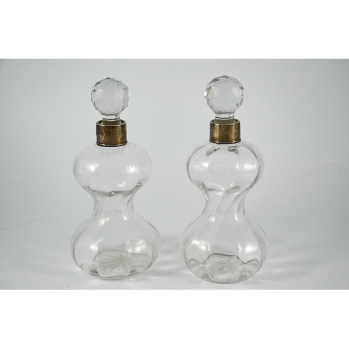 680 - A pair of Arts and Crafts glass decanters and stoppers, spiral hourglass form, with silver collars, ... 