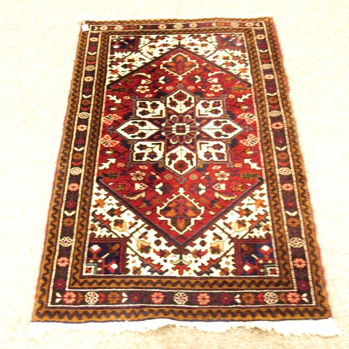 515 - An Iranian dark red, blue and cream ground fringed and bordered rug,  Mehriban design, 92cm x 140cm