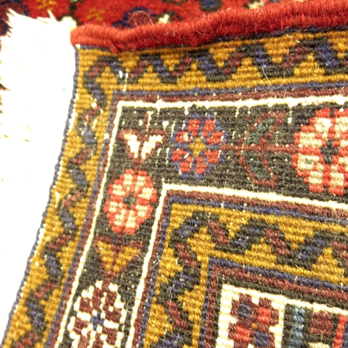 515 - An Iranian dark red, blue and cream ground fringed and bordered rug,  Mehriban design, 92cm x 140cm