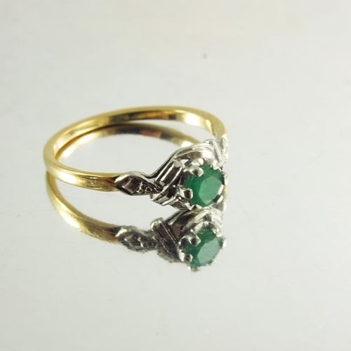 120 - An 18ct yellow gold ring inset with circular emerald in white metal decorative mount, stamped