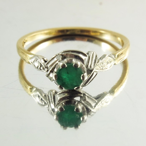 120 - An 18ct yellow gold ring inset with circular emerald in white metal decorative mount, stamped