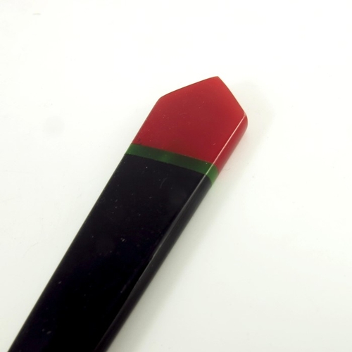 543 - An Art Deco bakelite letter opener, circa 1930 in black with red tip inlaid with green band 22cm lon... 