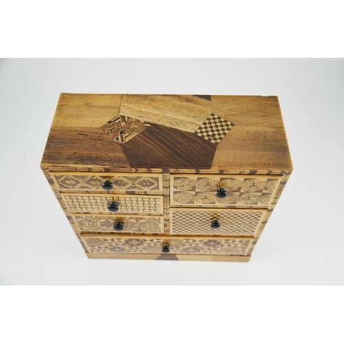 475 - A Japanese Hakone parquetry small chest of five short over one long drawers, each with different geo... 