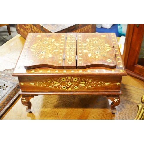 63 - An inlaid hardwood qur'an box, with lift up lid and twin easel bookrests on cabriole supports.