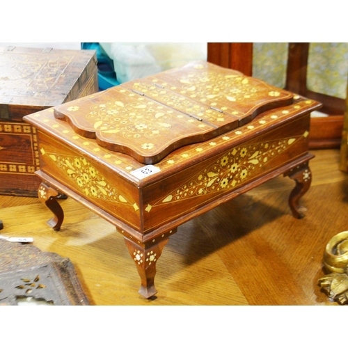 63 - An inlaid hardwood qur'an box, with lift up lid and twin easel bookrests on cabriole supports.