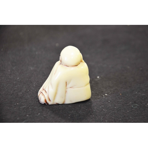 230 - Resin figure of a resting man, height 5cm.