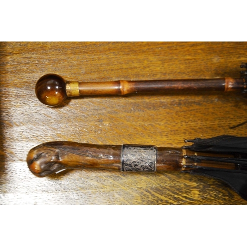 452 - Lady's black umbrella with cane handle and Tiger's Eye ball finial, and a gentleman's umbrella.  (2)