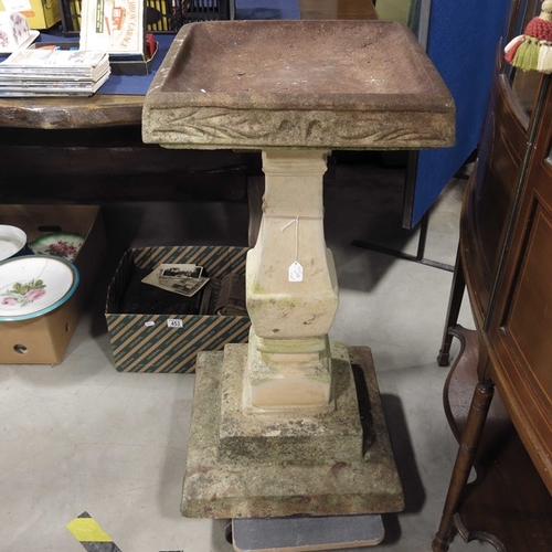 678 - A cast stone bird bath, rectangular top on square baluster column on stepped base.