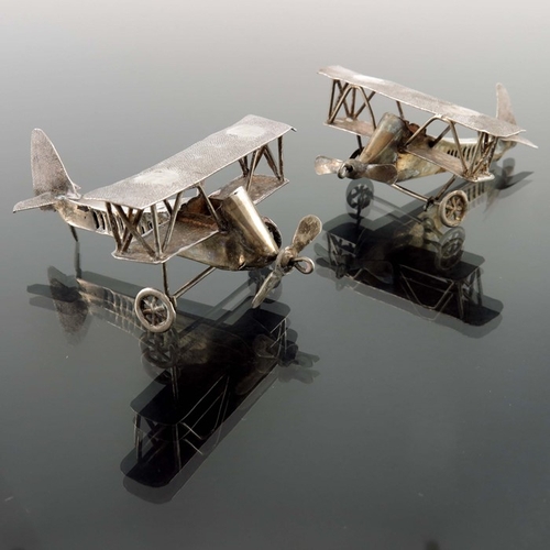 10 - A pair of novelty white metal aeroplanes, sheet and wire construction with movable wheels and propel... 
