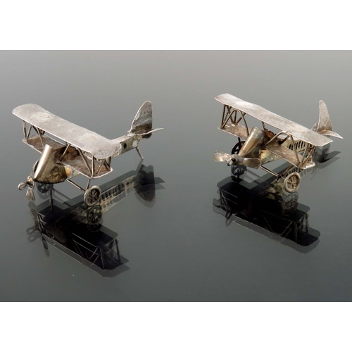 10 - A pair of novelty white metal aeroplanes, sheet and wire construction with movable wheels and propel... 