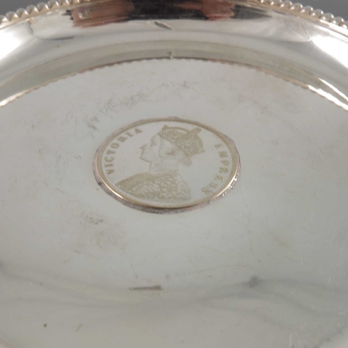 13 - Three Indian silver coin dishes, two set with Victoria Rupees, one embossed with a simulated Persian... 