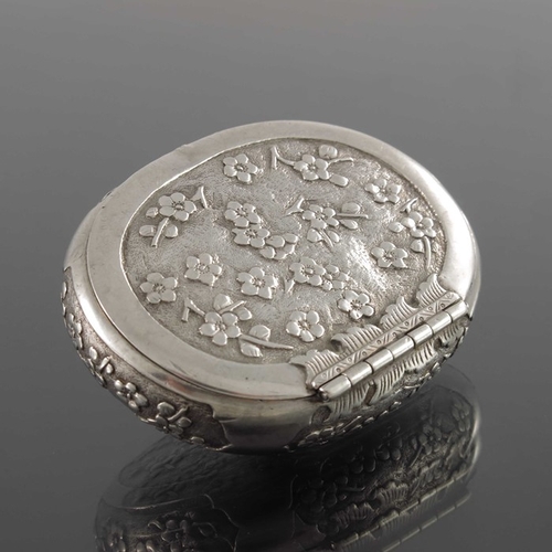 5 - A Chinese silver snuff box, 19th century, oval form, engraved and chased with prunus within ogee car... 