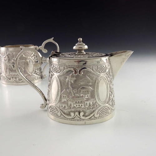 15 - A Chinese Persian style white metal teapot and sugar bowl, oval conical form, repousse embossed and ... 