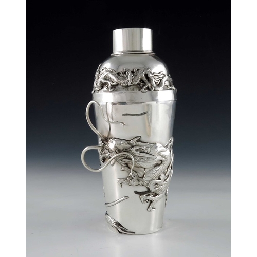 10 - A Chinese silver cocktail shaker, circa 1920, the body applied with a cast dragon in relief amongst ... 